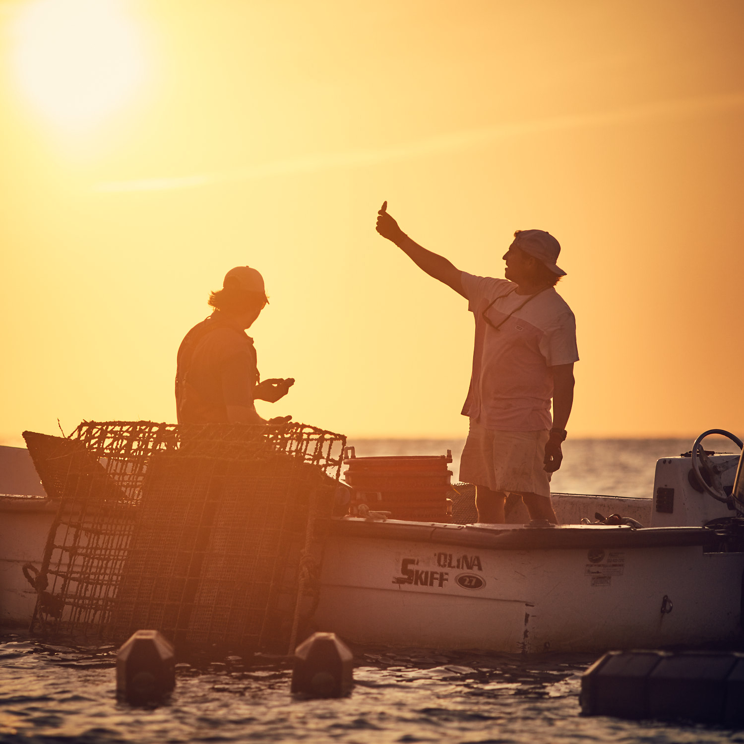 Oyster farm at sunset — two figures in a boat